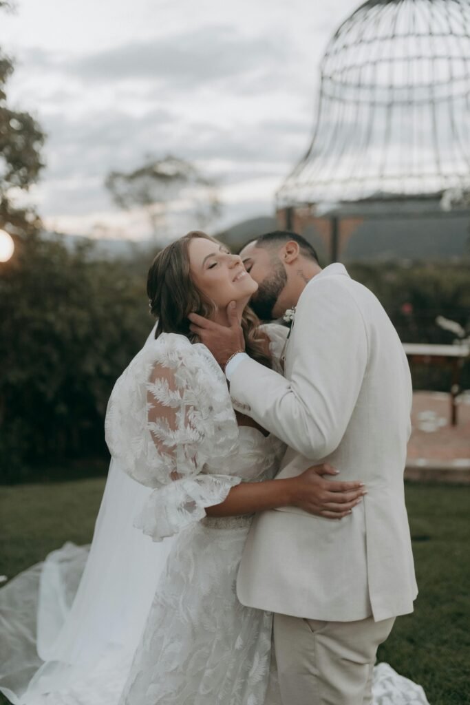 Bride and groom sharing a tender moment on their wedding day outdoors.